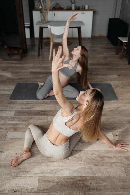 Woman meditating in a lotus pose on a yoga mat in a room filled with natural light.